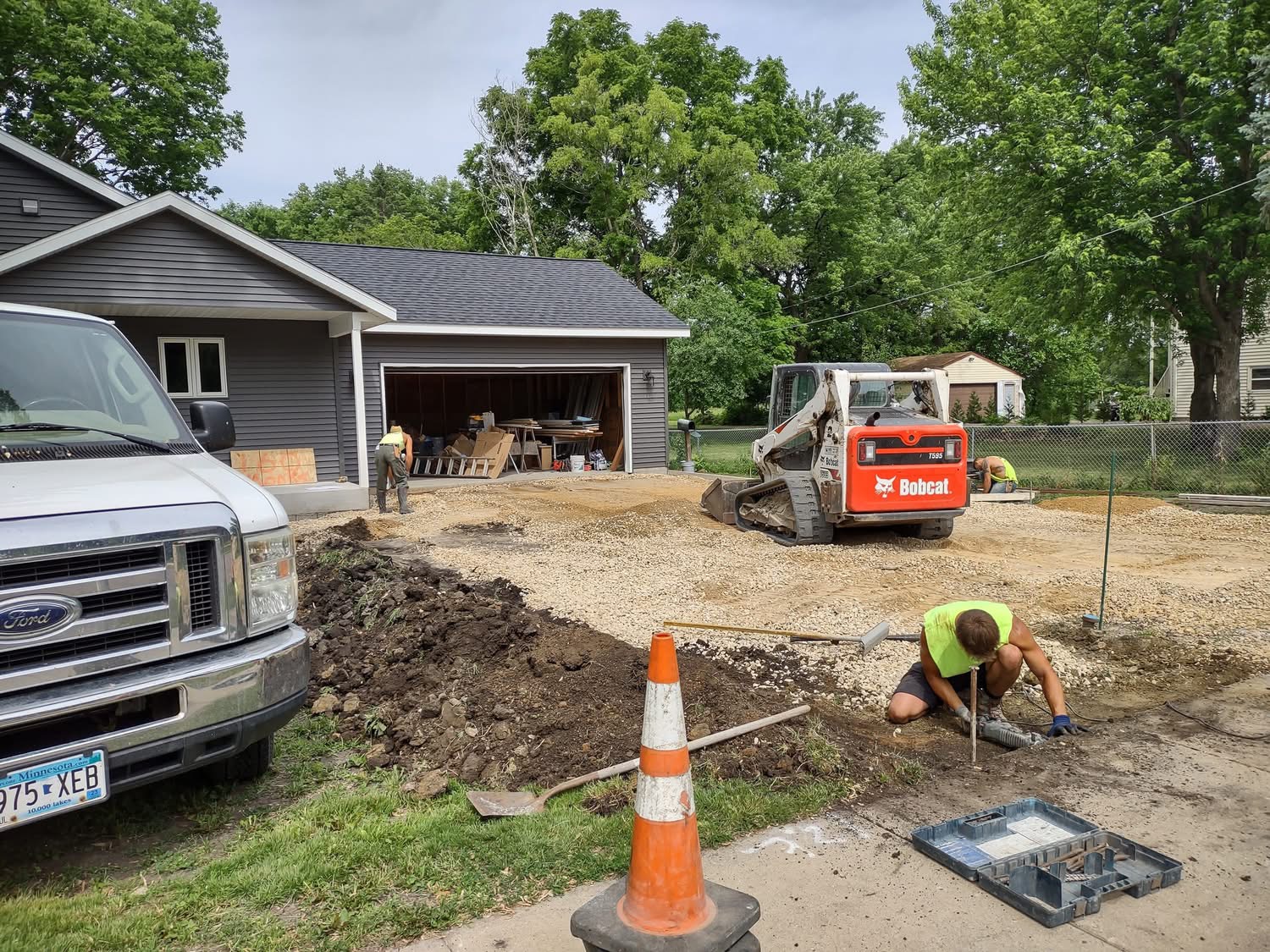 Clint Adams Concrete crew in signature neon shirts preparing the base beside a garage