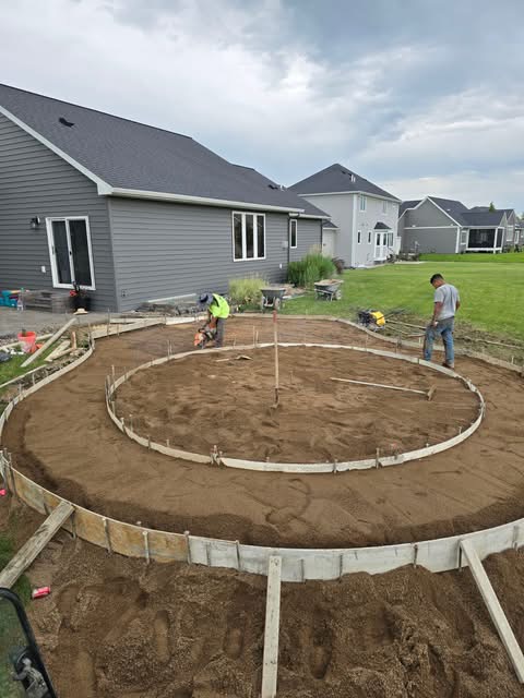 Crew forming a large round patio in a backyard
